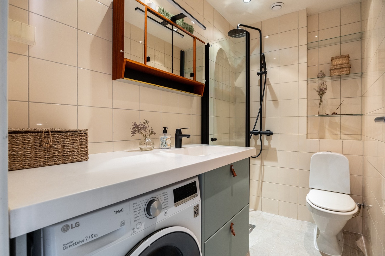 Videre har leiligheten et helfliset bad med varmekabler i gulvet. Galleribilde