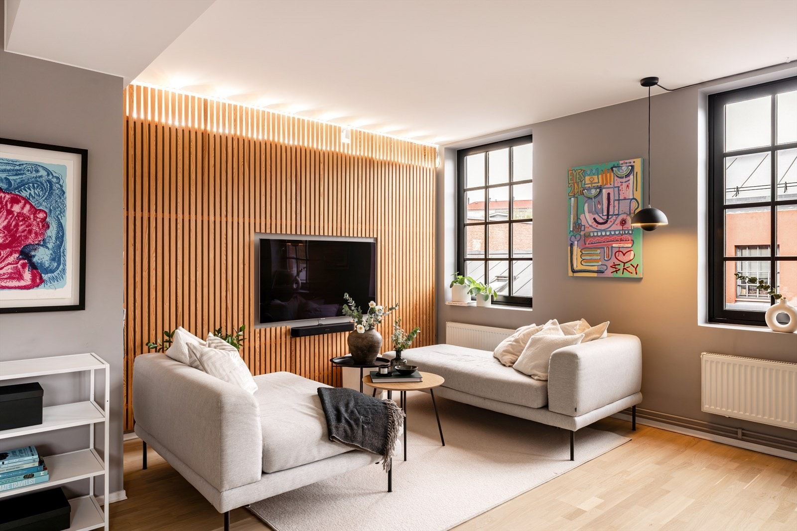 Store vinduer med industripregede detaljer og en lekker spilevegg gir stuen karakter. Galleribilde