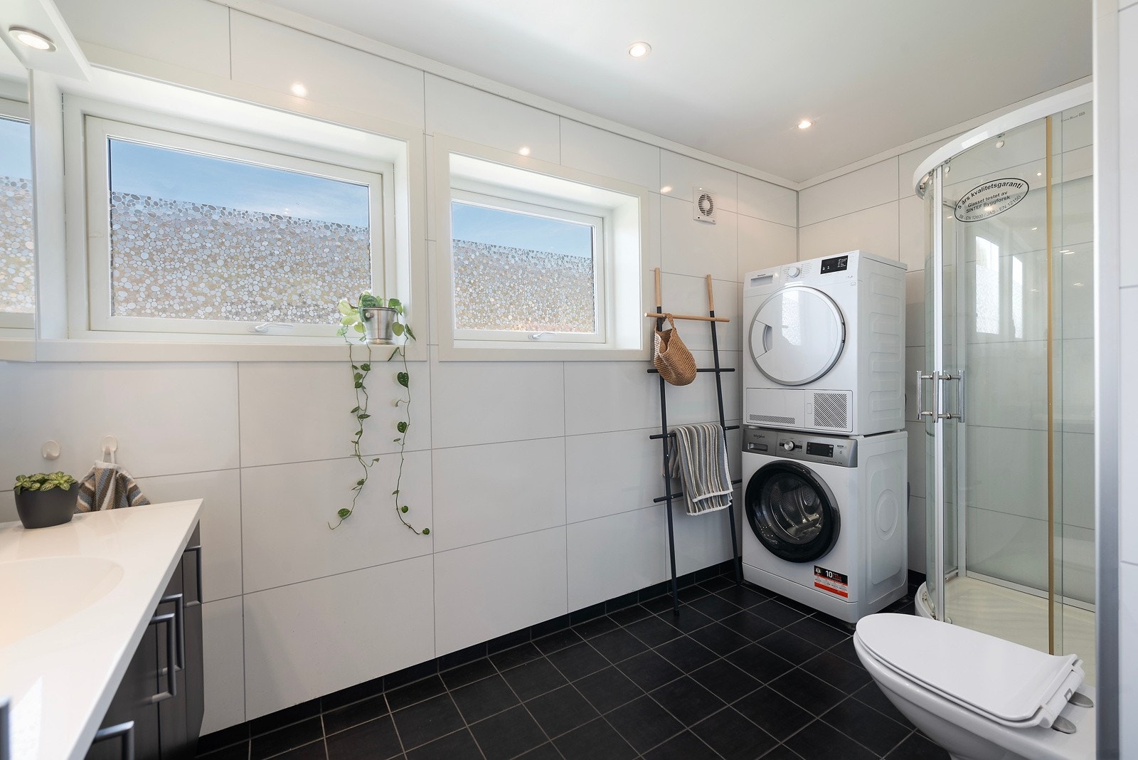 På badet har du flislagt gulv med varmekabler og god plass til vaskemaskin og tørketrommel Galleribilde