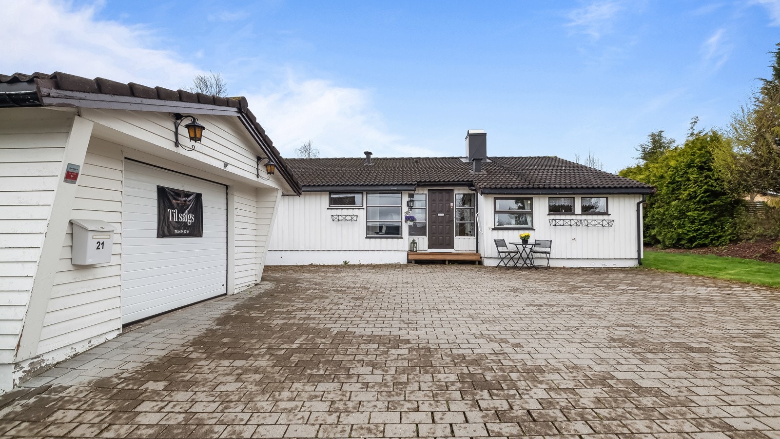 Stor gårdsplass og garasje med nyere leddport med elektrisk åpner. Galleribilde