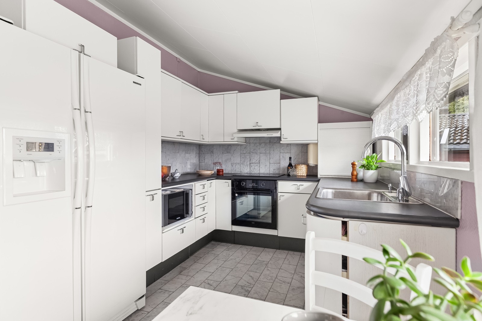 Det er komfyr og induksjonstopp, opplegg for oppvaskmaskin og avsatt plass til kjøl/fryseskap. Galleribilde