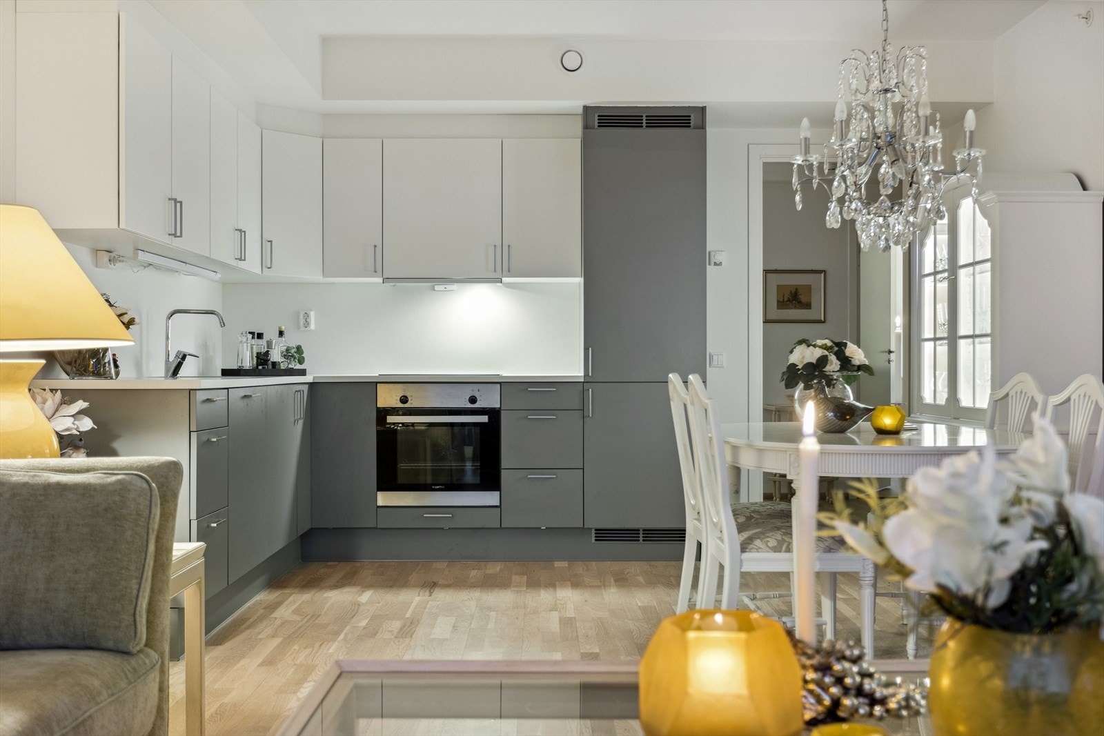 Høyskap og takoppforede overskap gir god oppbevaringsplass, mens den mørke laminatbenkeplaten og de slette, hvite frontene tilfører et moderne preg. Galleribilde