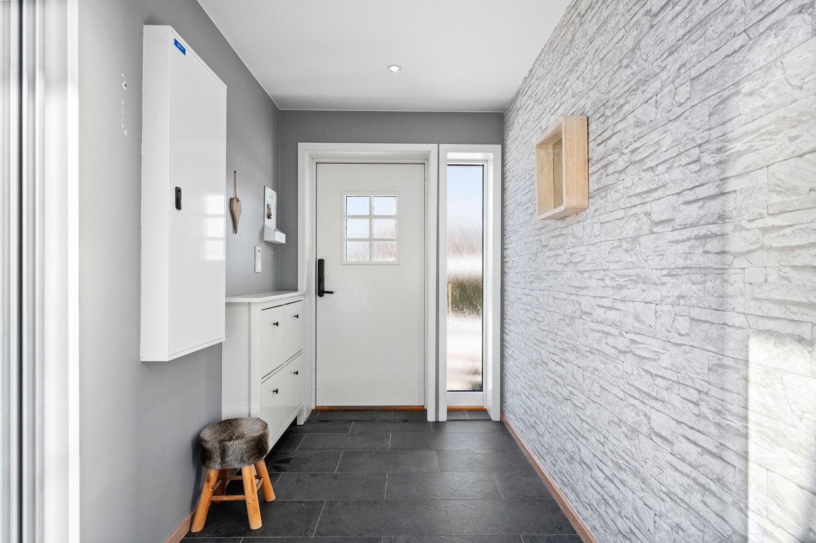Entré med fliser på gulv, tapet samt malte vegger og malt himling. Selger opplyser om at det er klargjort for smarthus i boligen! Galleribilde