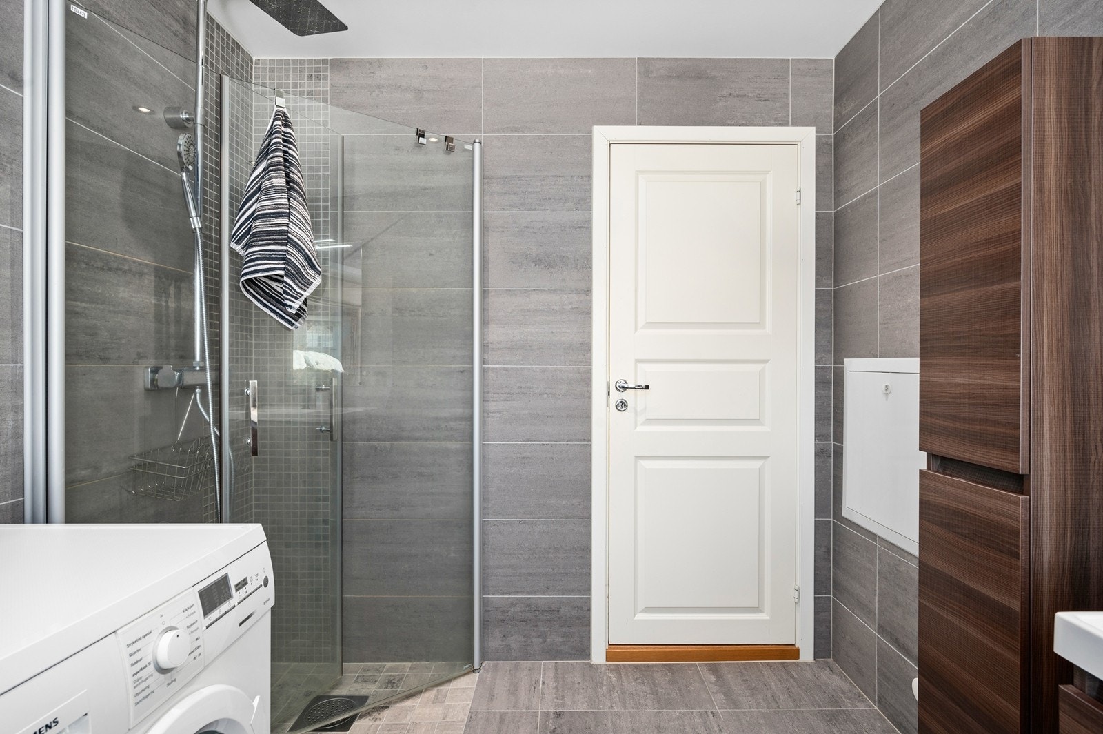 Badet har dusjhjørne med foldedører av glass og regnfallsdusj Galleribilde