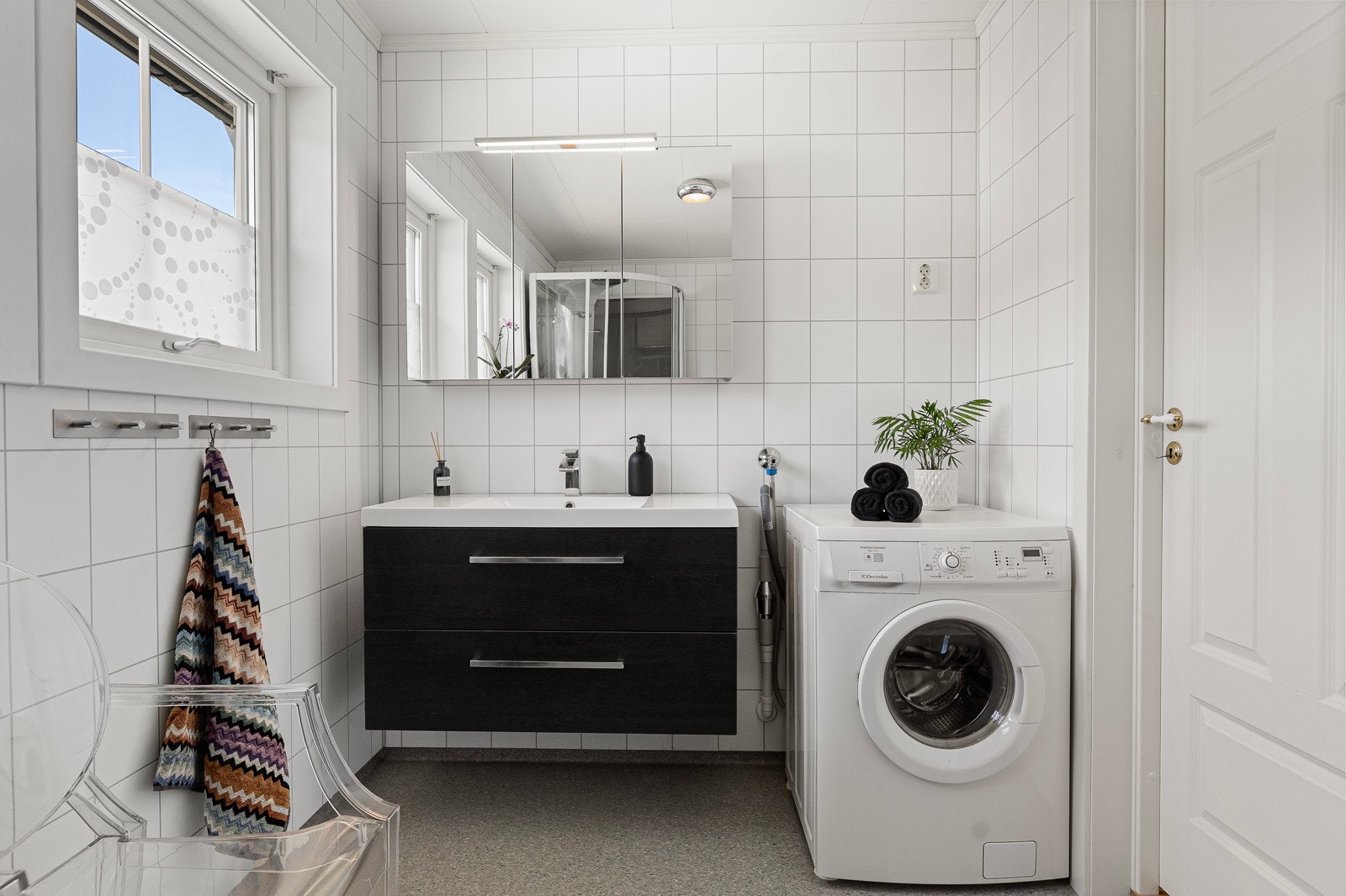 Innredning bestående av vegghengt servantinnredning, ovenpåliggende servant med armatur og speilskap med overlys. Galleribilde