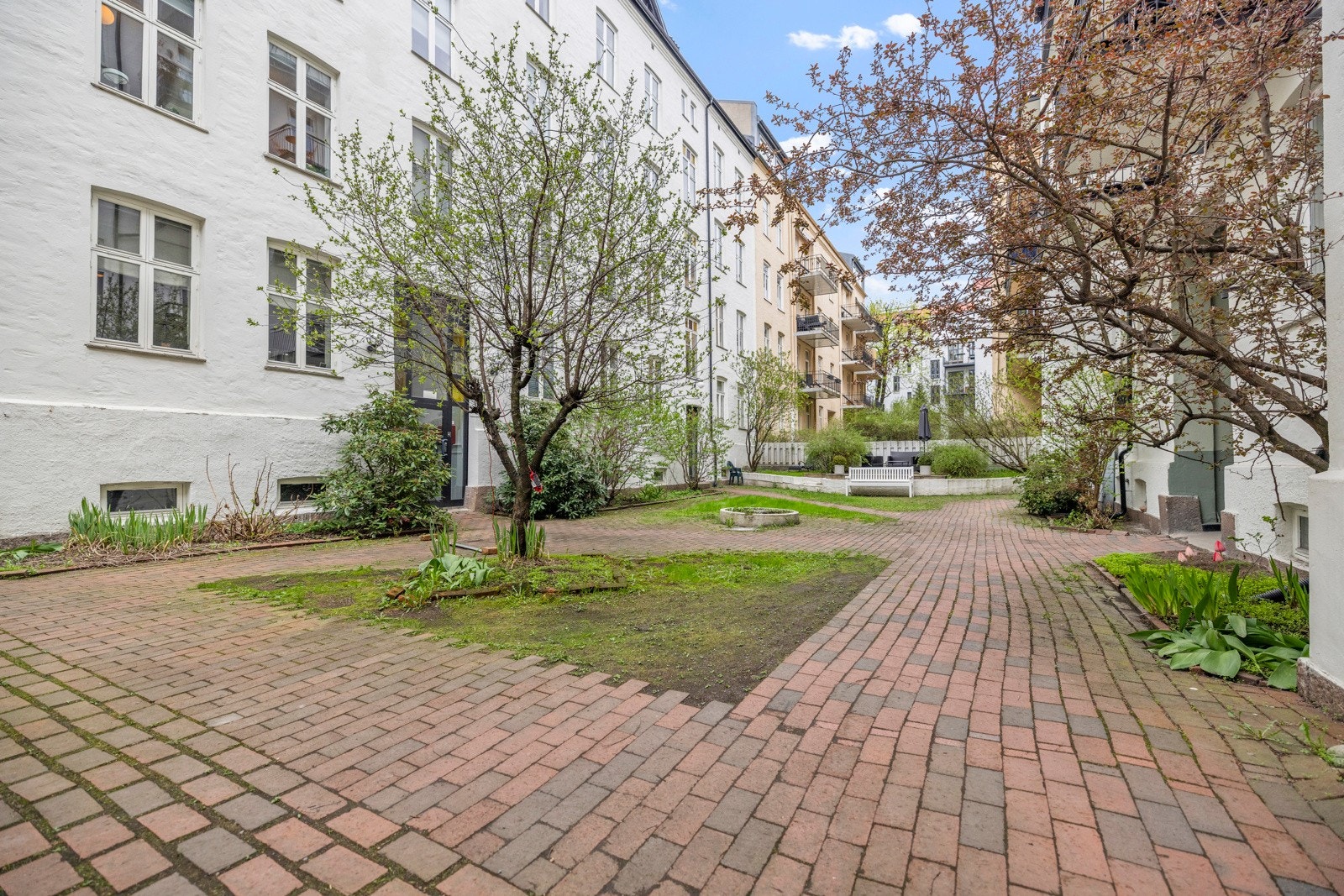 Fin bakgård som er opparbeidet med div- beplantninger og sittegruppe. Galleribilde