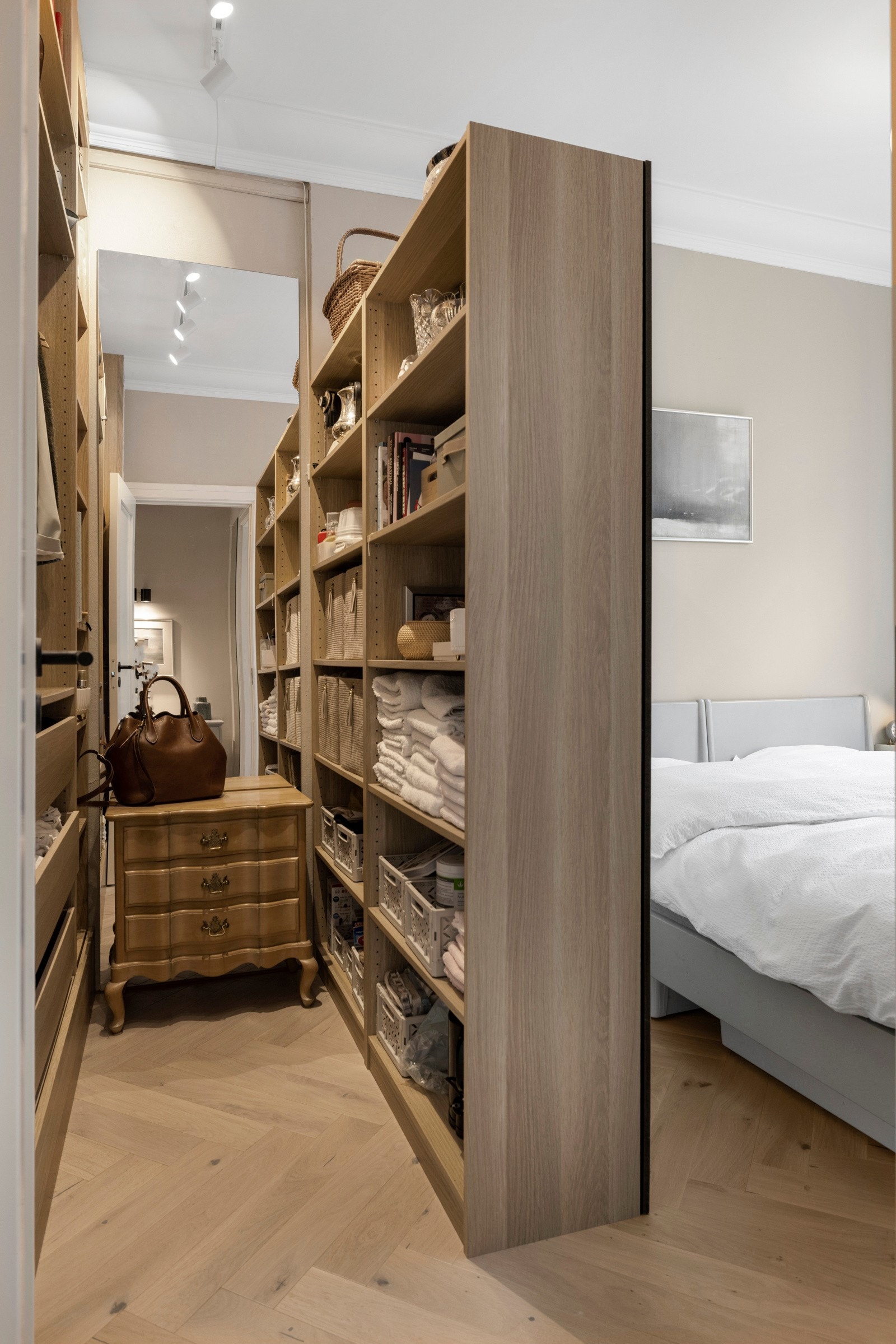 Rikelig oppbevaringsplass i innredning med hyller, skuffer og kleshengerstativ. Galleribilde