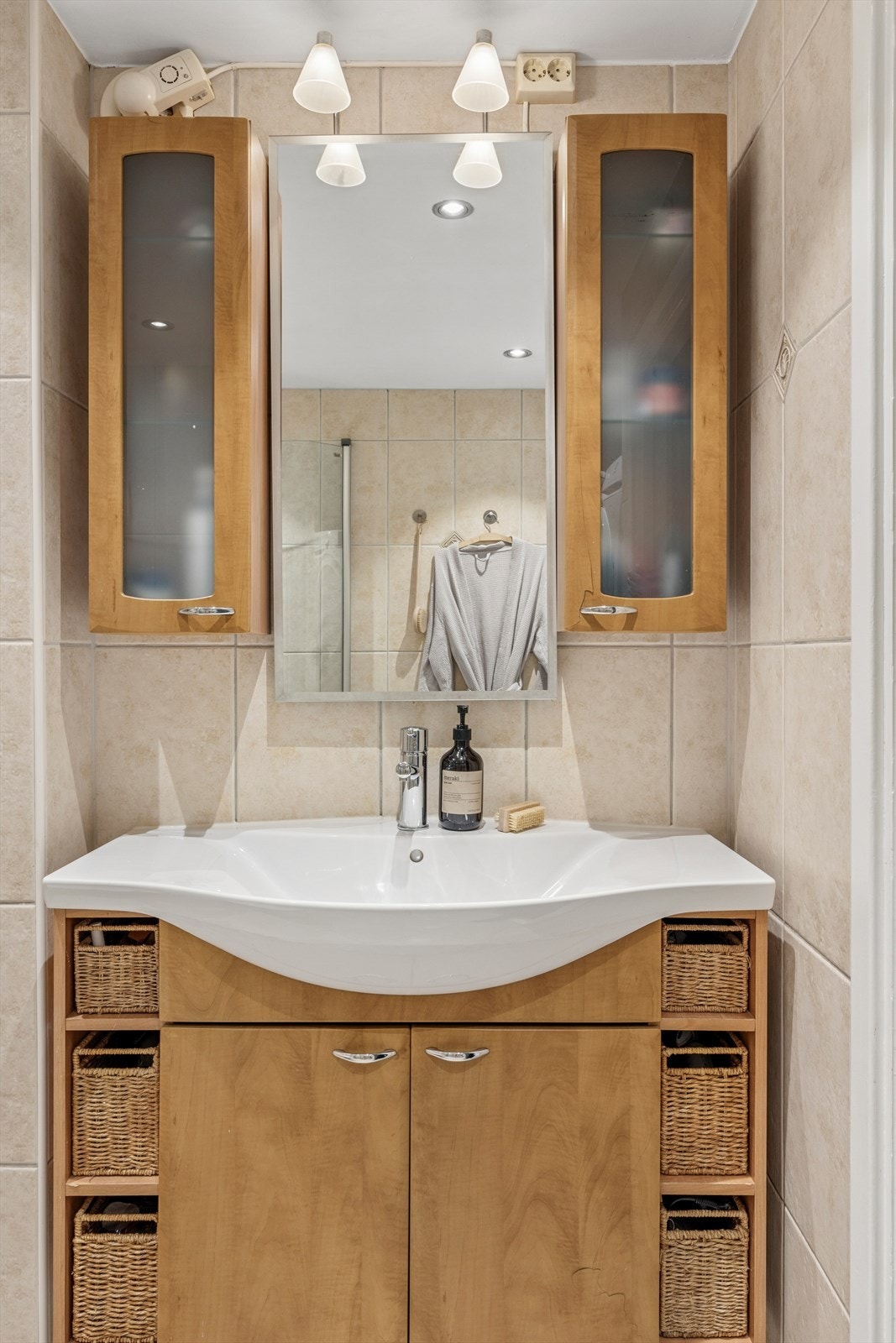 Servant med under- og overskap med gode oppbevaringsmuligheter. Belysning over speil. Galleribilde