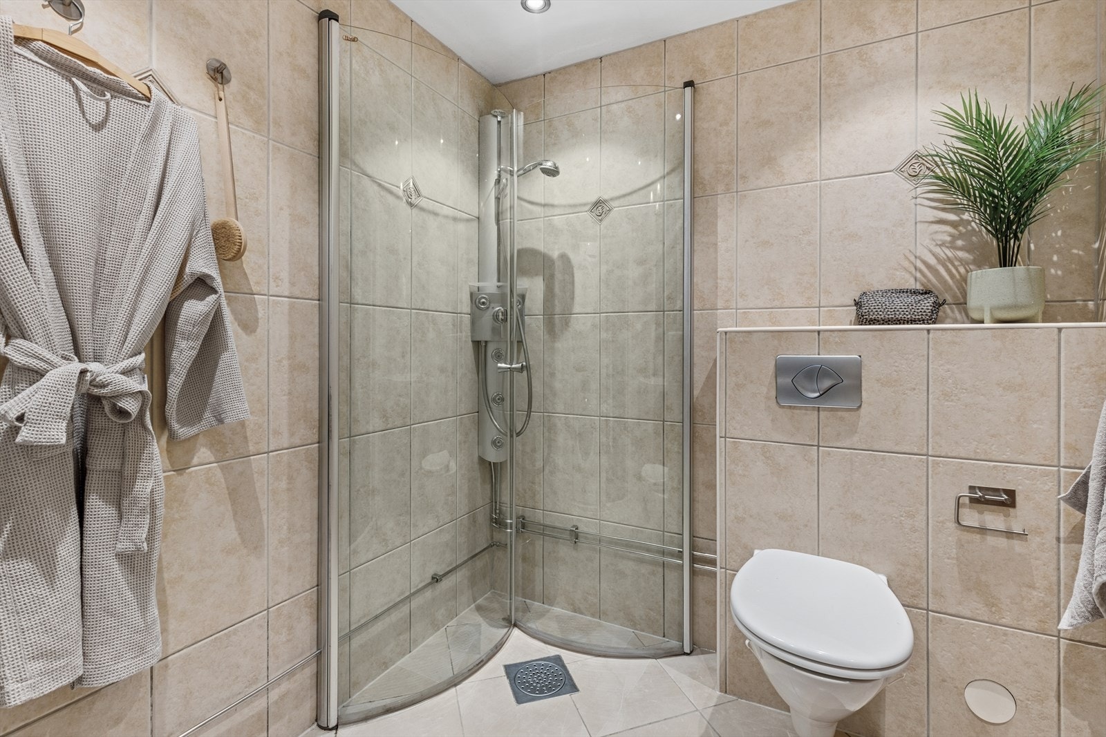 Eldre baderom med varmekabler i baderomsgulv og downlights i himling. Galleribilde