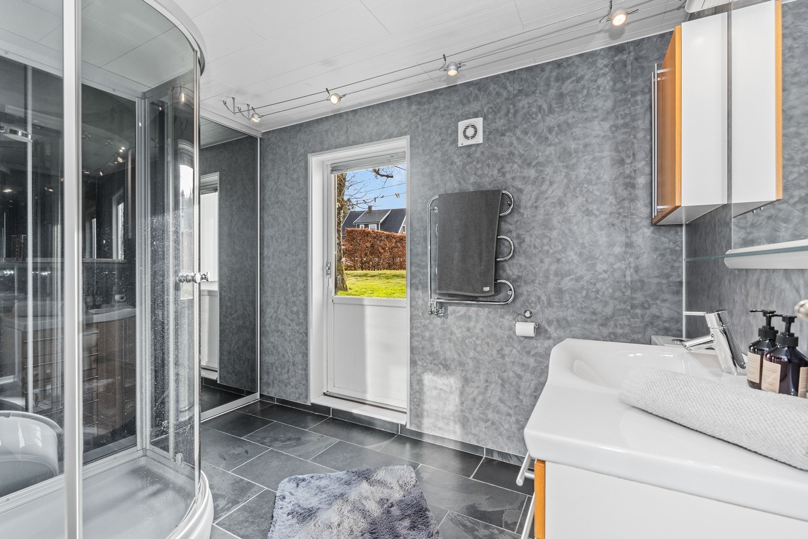 Bad/vaskerom i 1. etg. Her er opplegg til vaskemaskin bak skyvedørsgarderibe og direkte utgang til hage. Galleribilde