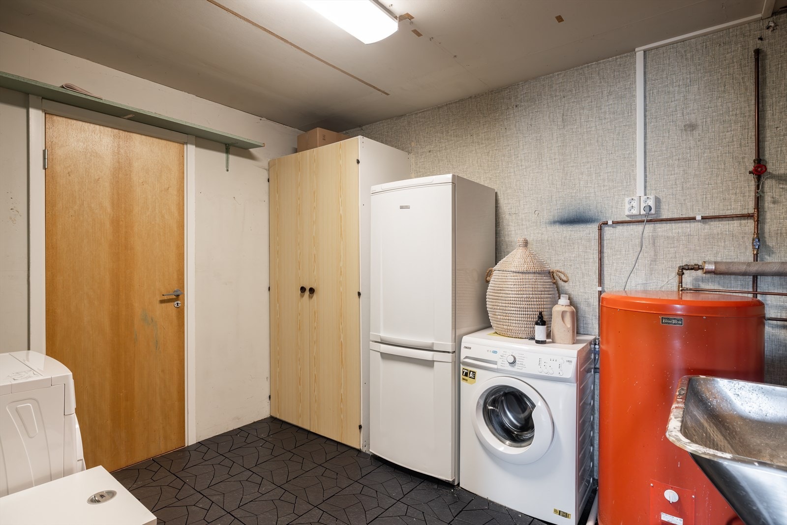 Ved siden av badet er det et praktisk vaskerom. Videre kommer du inn til en matbod og så en stor bod/hobbyrom. Galleribilde