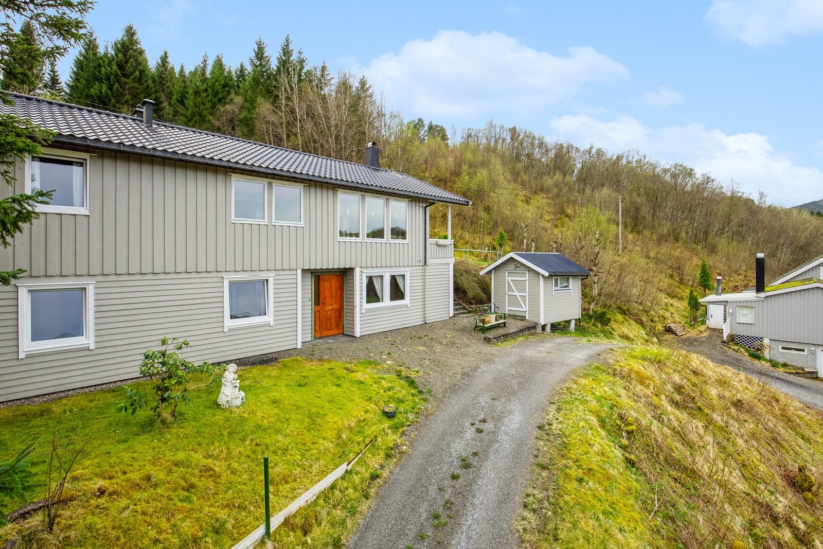 Tomten er opparbeidet med plenareal, treterrasser, prydbusker og gruset gårdsplass etc. Galleribilde