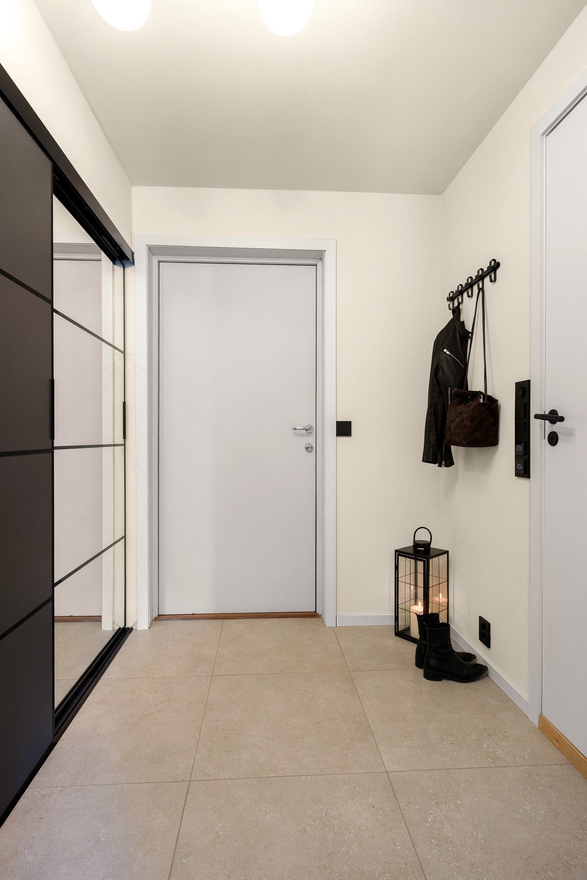 Lys og innbydende entré med skyvedørsgarderobe. Galleribilde