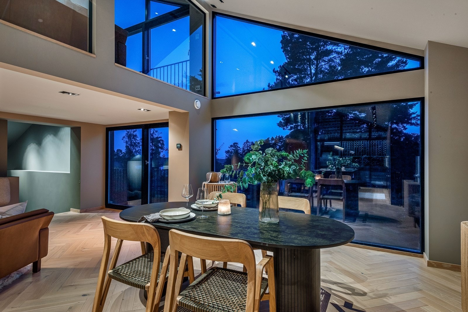 Vinduer fra gulv-til-tak gir utsikt over hagen, mot skog og noe sjøutsikt. Galleribilde