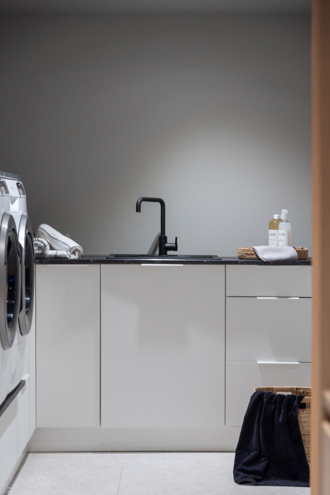 Vaskerommet har design med nøytrale farger, hovedsakelig i grått, sort og hvitt, som bidrar til et rent og minimalistisk utseende. Galleribilde