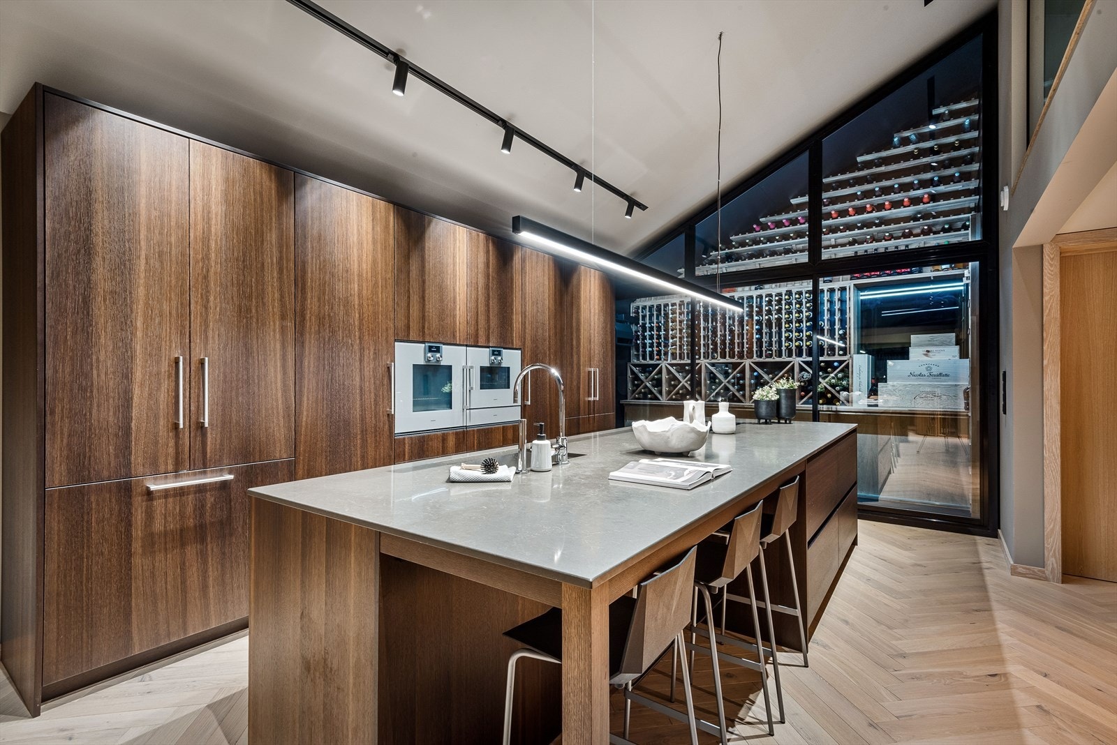 Belysningen er slank og minimalistisk, med spotlights i tak, hengelampe og skap som lyser opp arbeidsområdet. Galleribilde