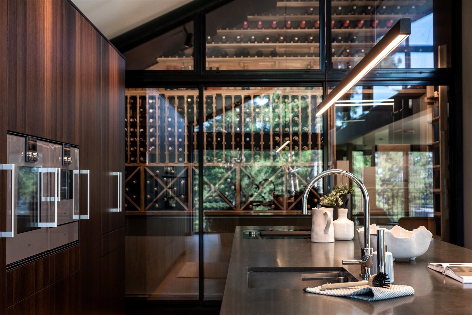 Vinrommet er synlig gjennom kjøkkenets glassvegg, noe som gir et interessant og luksuriøst element til rommet. Galleribilde