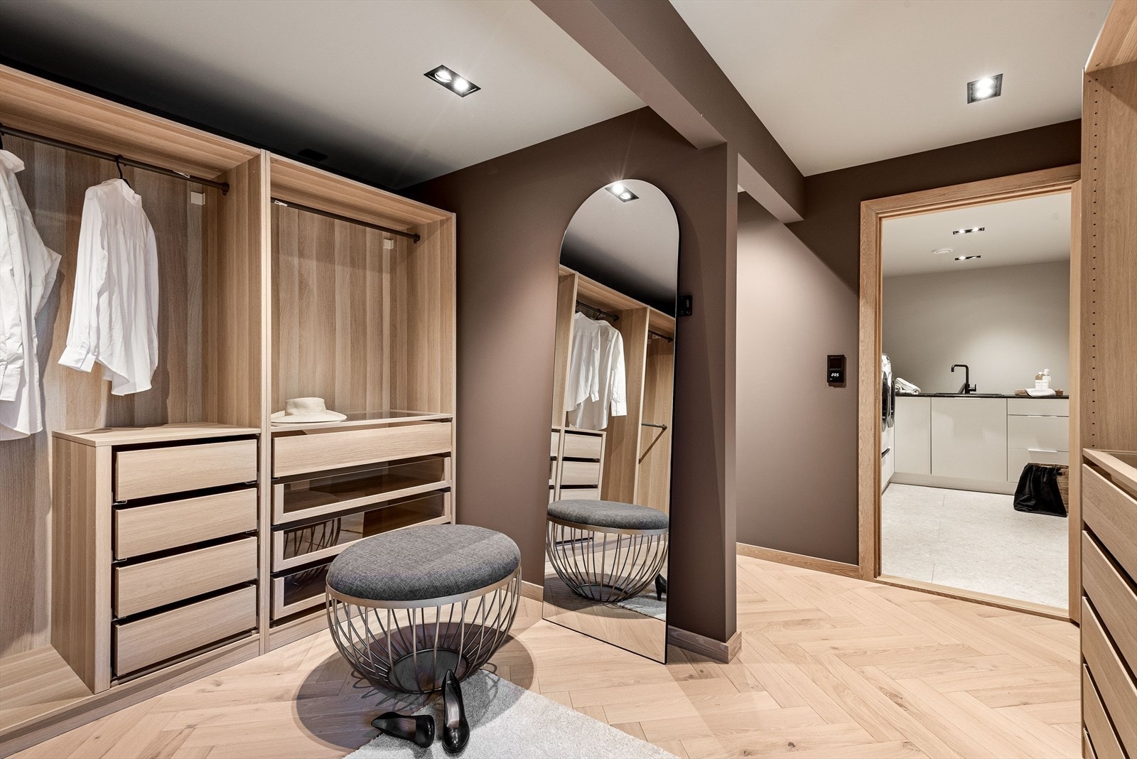 Walk-in garderoben er innredet med åpne hyller, skuffer og rikelig med hengeplass, slik at du kan holde klærne dine organisert og lett tilgjengelige. Galleribilde