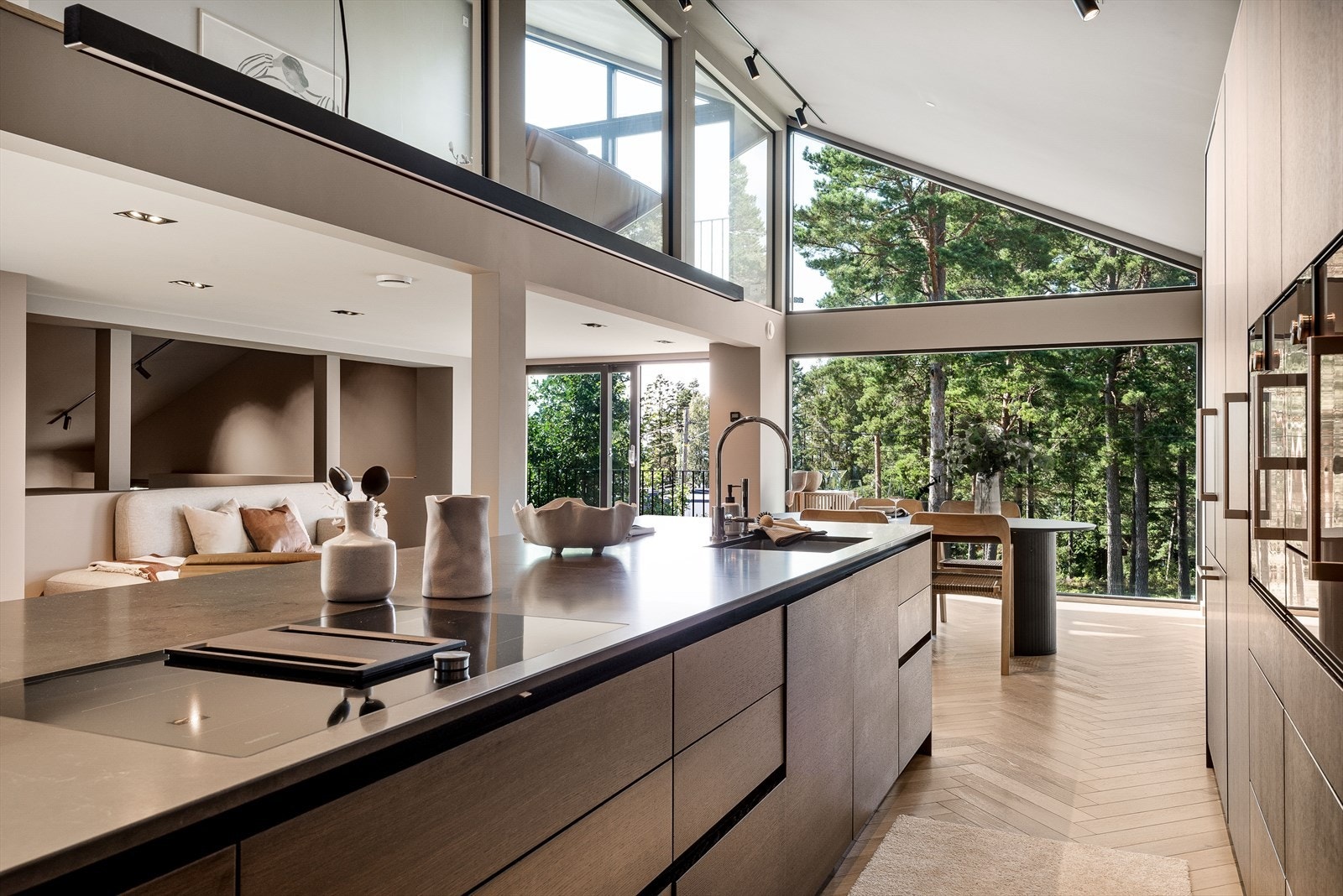 Sentralt i rommet er en stor øy med benkeplate i polert stein og rikelig med oppbevaring. Galleribilde