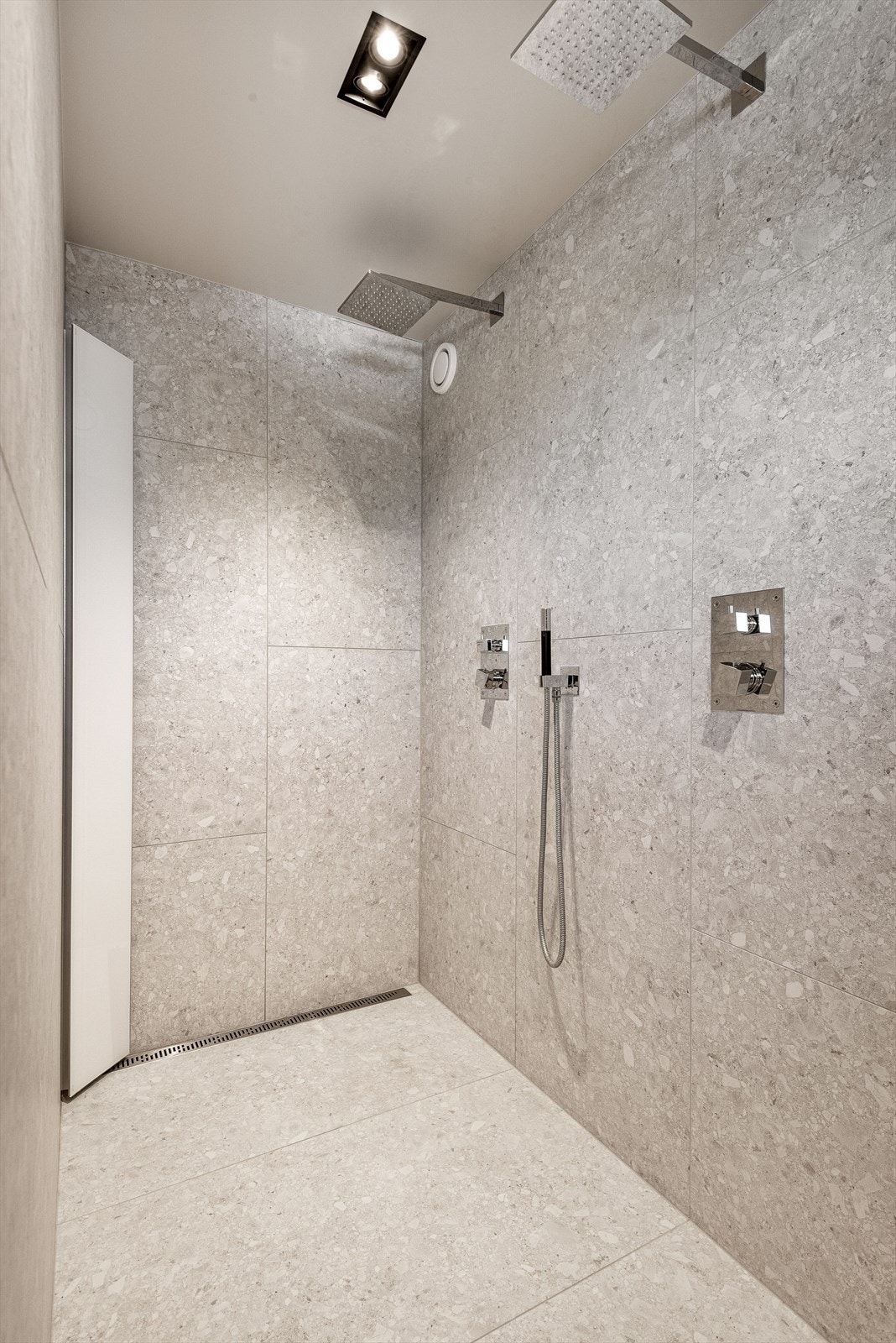 Dusjen er utstyrt med to regnfallsdusjer i tak og en justerbar hånddusj montert på veggen. Galleribilde