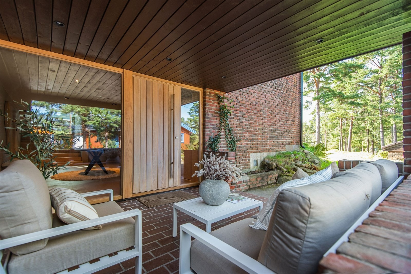 Huset har en elegant spesialbygd inngangsdør i eik. Ved inngangspartiet er det plass til en hyggelig sosial sone. Galleribilde