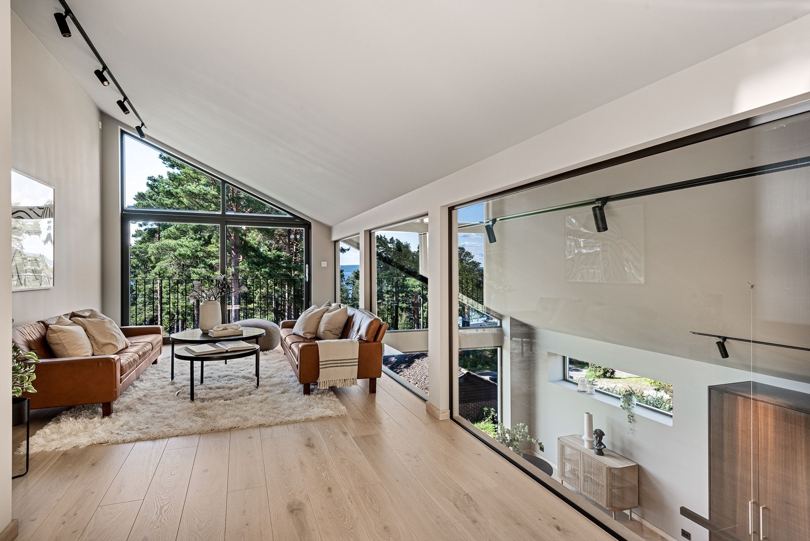 Også her er det store vinduflater som slipper inn rikelig med naturlig lys og et høyt, skrått tak med spotlights. Galleribilde