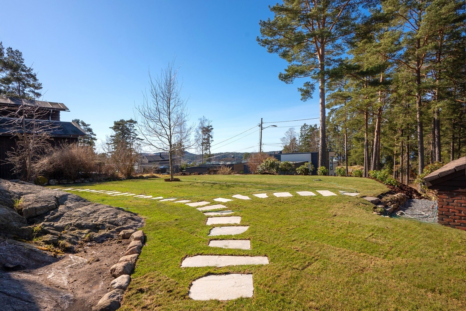 Det er laget en buet steinvei som snor seg gjennom en frodig gressplen. Omgitt av trær og busker, og noe skjermet, er dette det perfekte stedet for en dag i solen Galleribilde