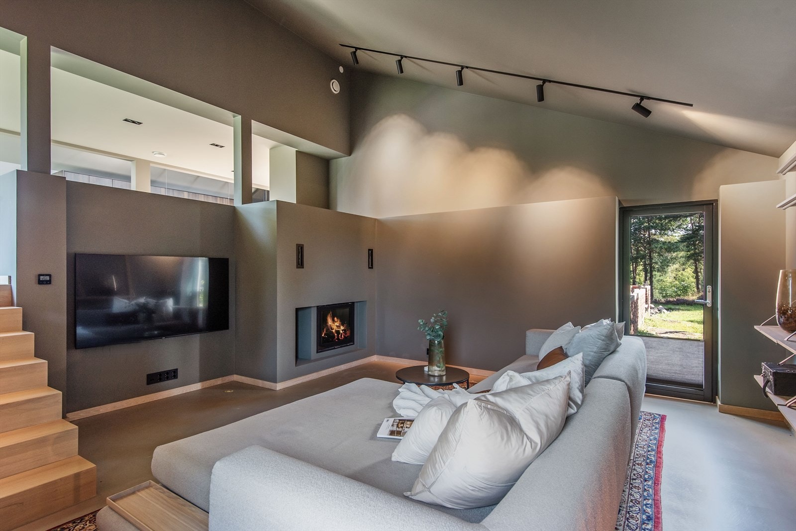 Herfra er det direkte utgang til uteplass på begge sider, med to dører som fører ut til hagen og terrenget. Galleribilde