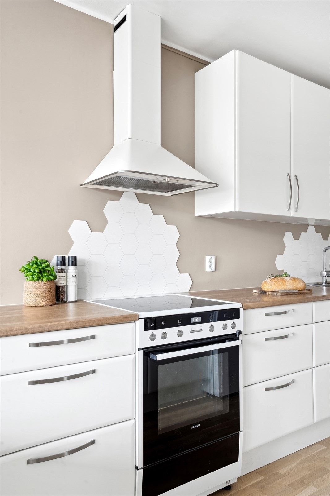 Veggen bak kokesonen og oppvaskkummen er beskyttet med hvite hexagonfliser. Galleribilde