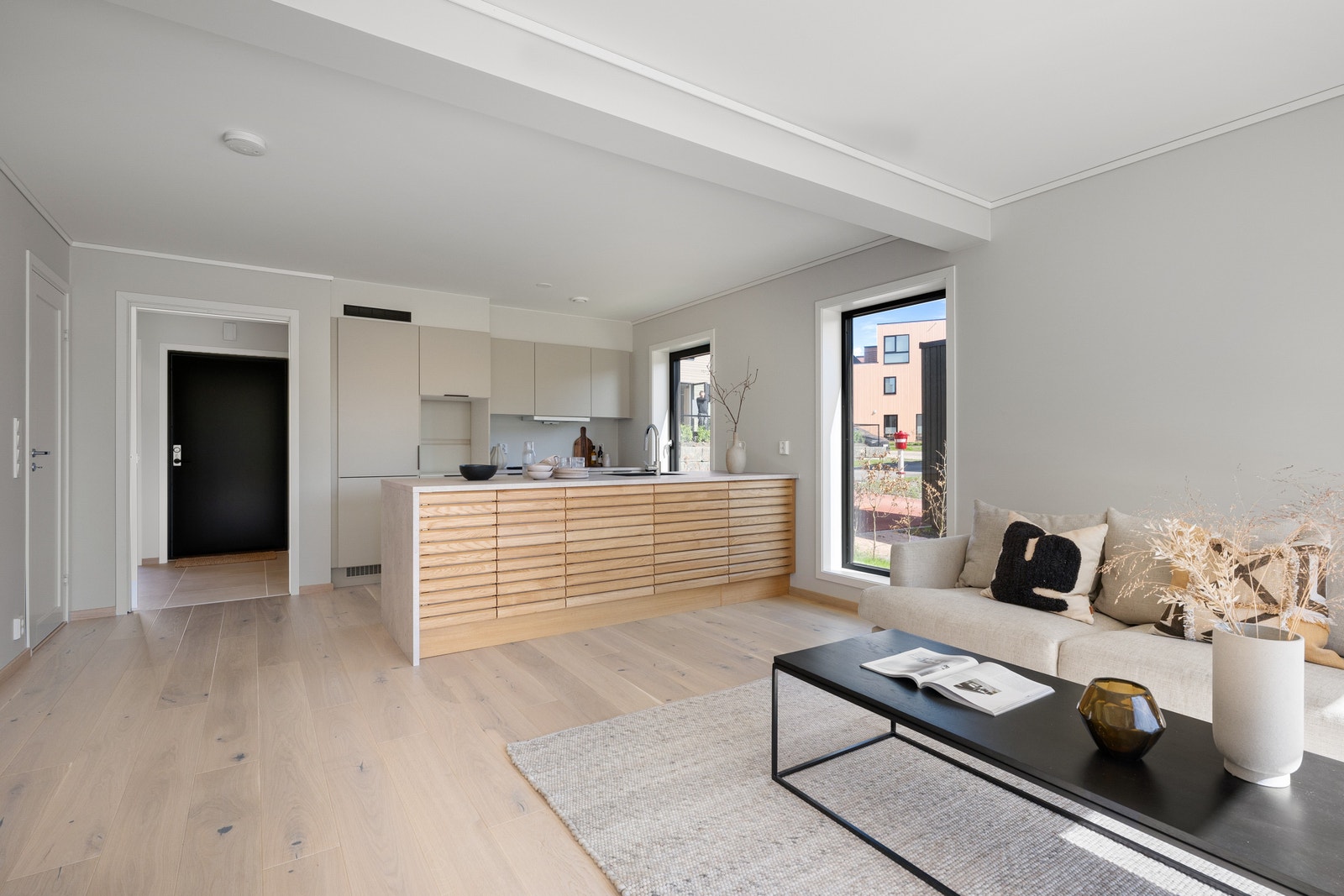 I 1. etasje har man et lyst og moderne oppholdsrom med delikate materialvalg og åpen kjøkkenløsning. Galleribilde