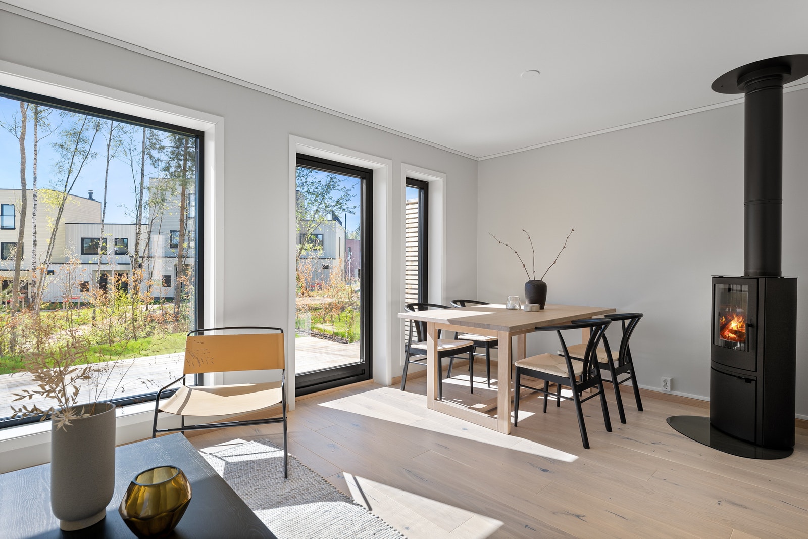 Spisestue med peisovn. Utgang til solrik markterrasse fra stue. Galleribilde