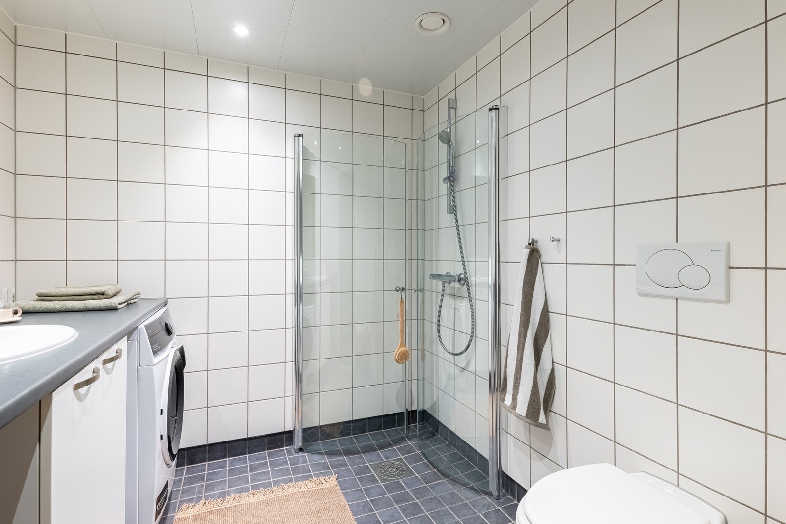 Videre er det vegghengt toalett og dusjhjørne med svingbare dører som frigjør plass på gulvet. Mekanisk avtrekksvifte. Galleribilde