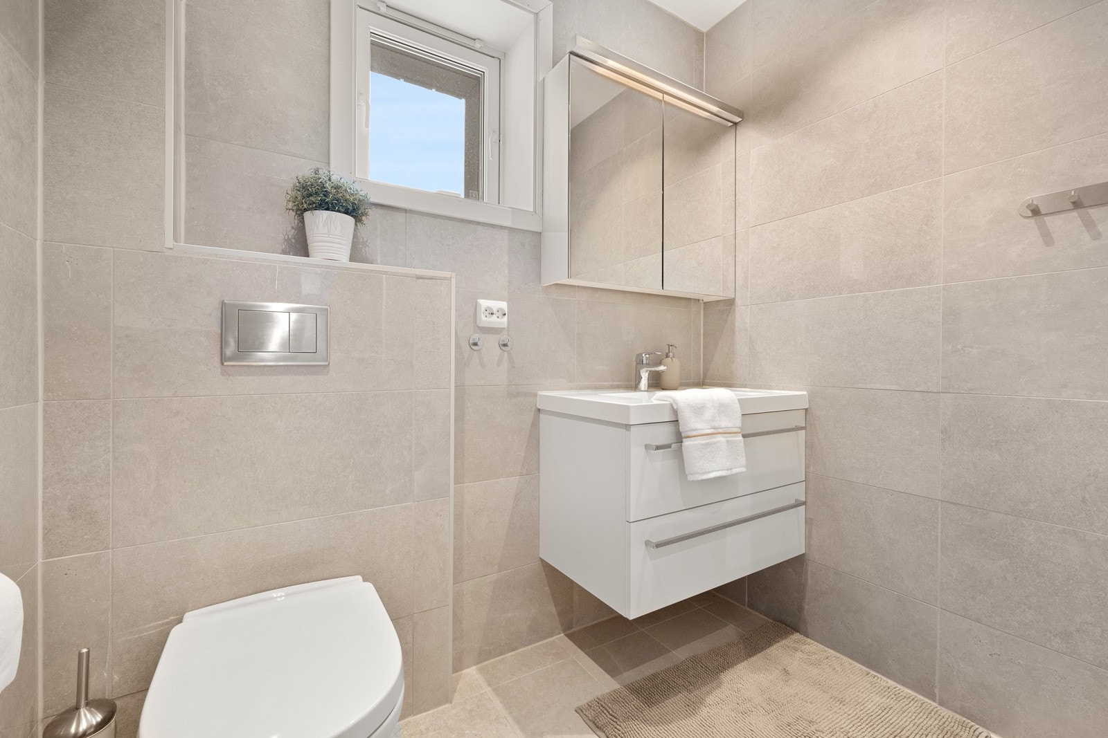 Rommet har også gulvvarme og veggmontert toalett, samt en romslig dusjnisje med regnfallsdusj og hånddusj. Galleribilde