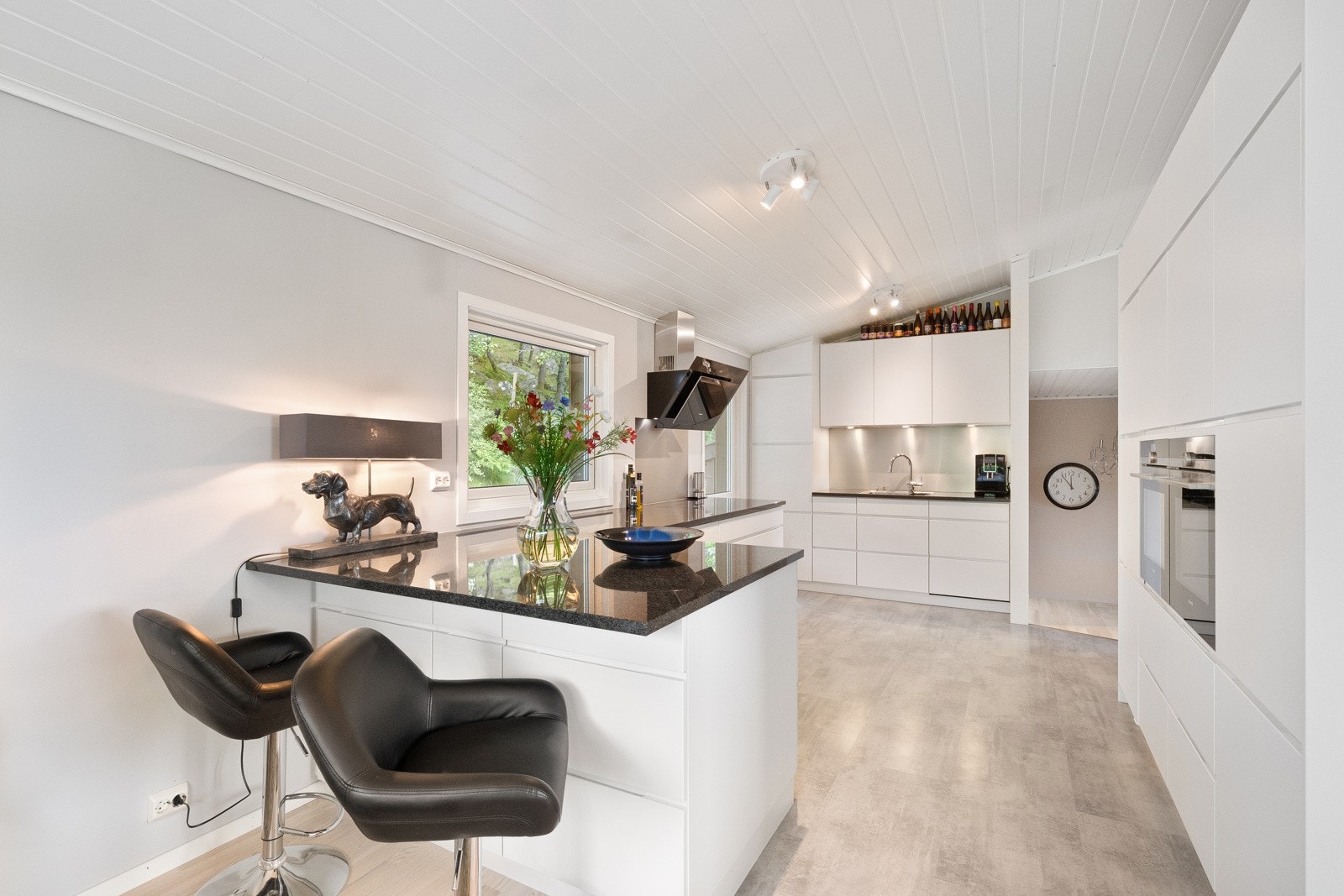 Innredningen har hvite, glatte fronter og en mørk benkeplate av stein. Galleribilde