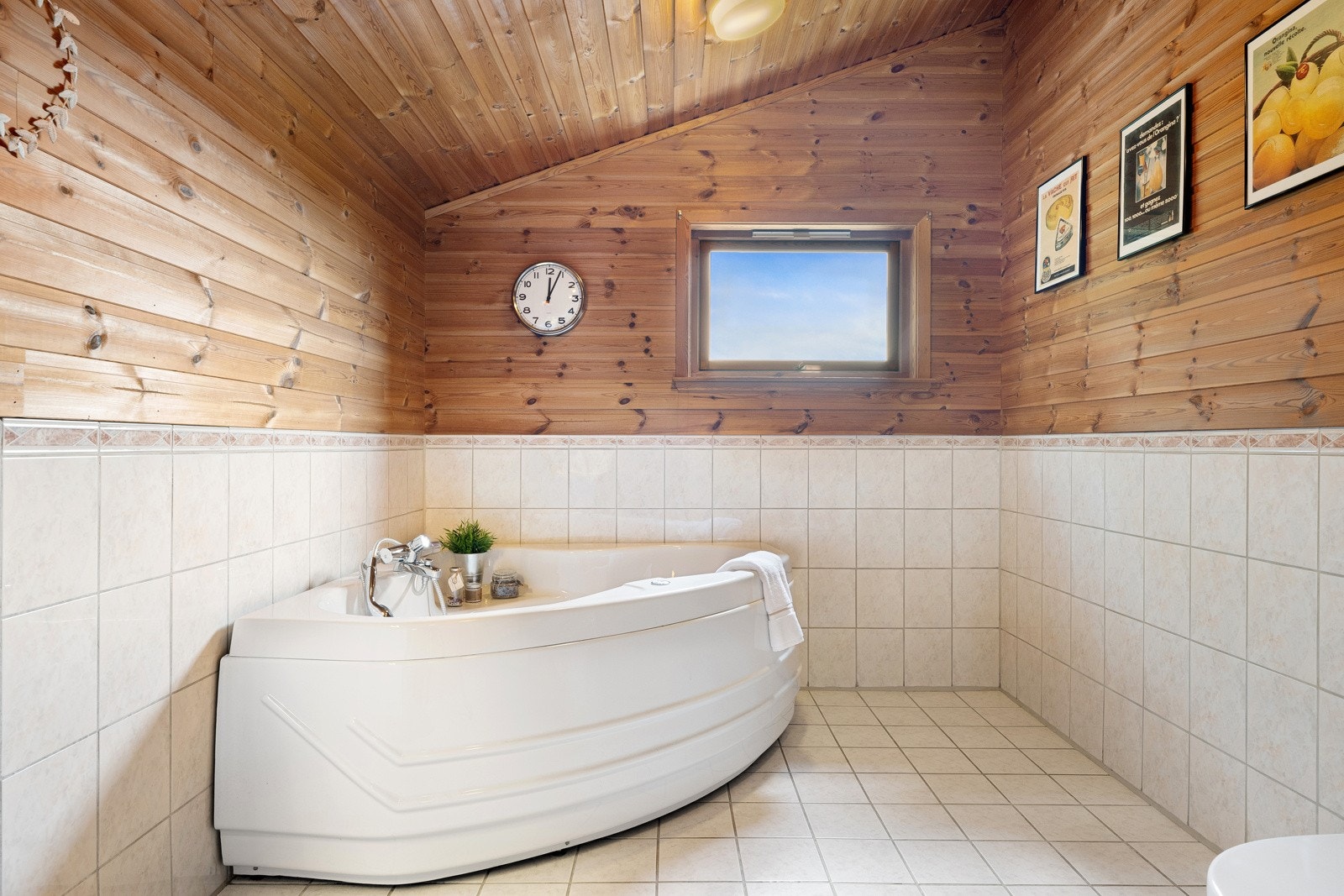 Rommet har også hjørnebadekar, dusjhjørne og et gulvmontert toalett. Innredningen består av en heldekkende servant med underskap, skuffer og matchende veggskap. Galleribilde