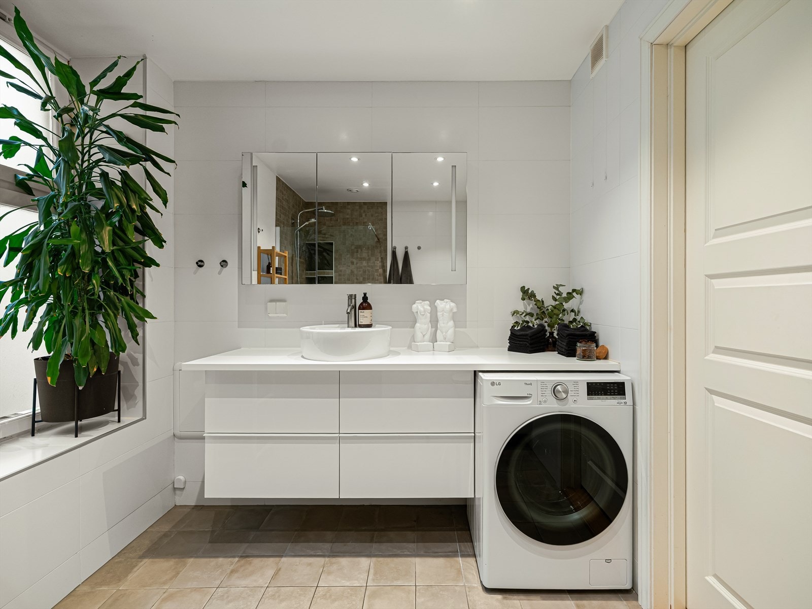 Badet har servantinnredning med skuffer og speilskap, vegghengt toalett og dusjnisje med glassvegg. Galleribilde