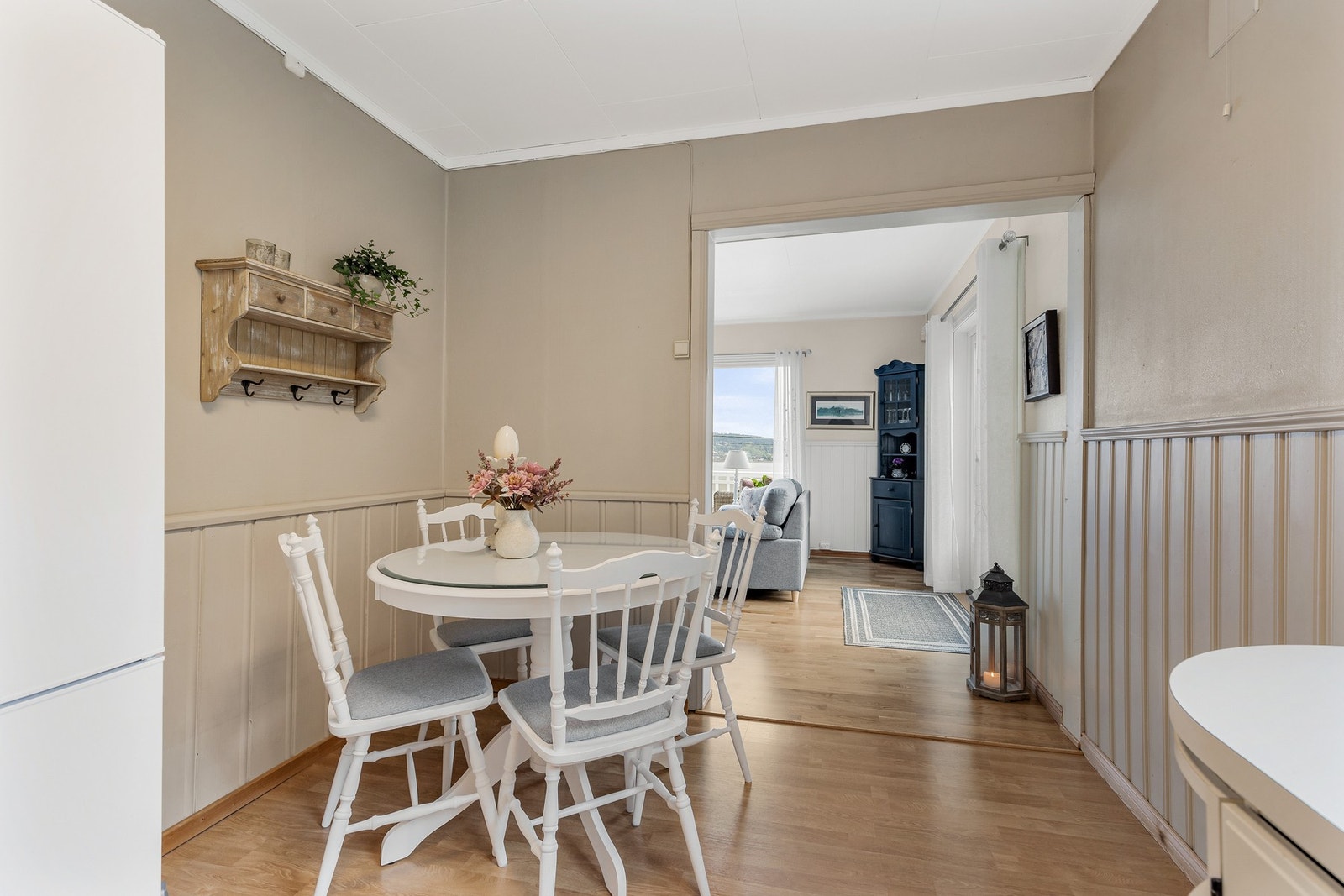 Det er lagt laminat på gulv og vegger er kledd med panel og tapet Galleribilde