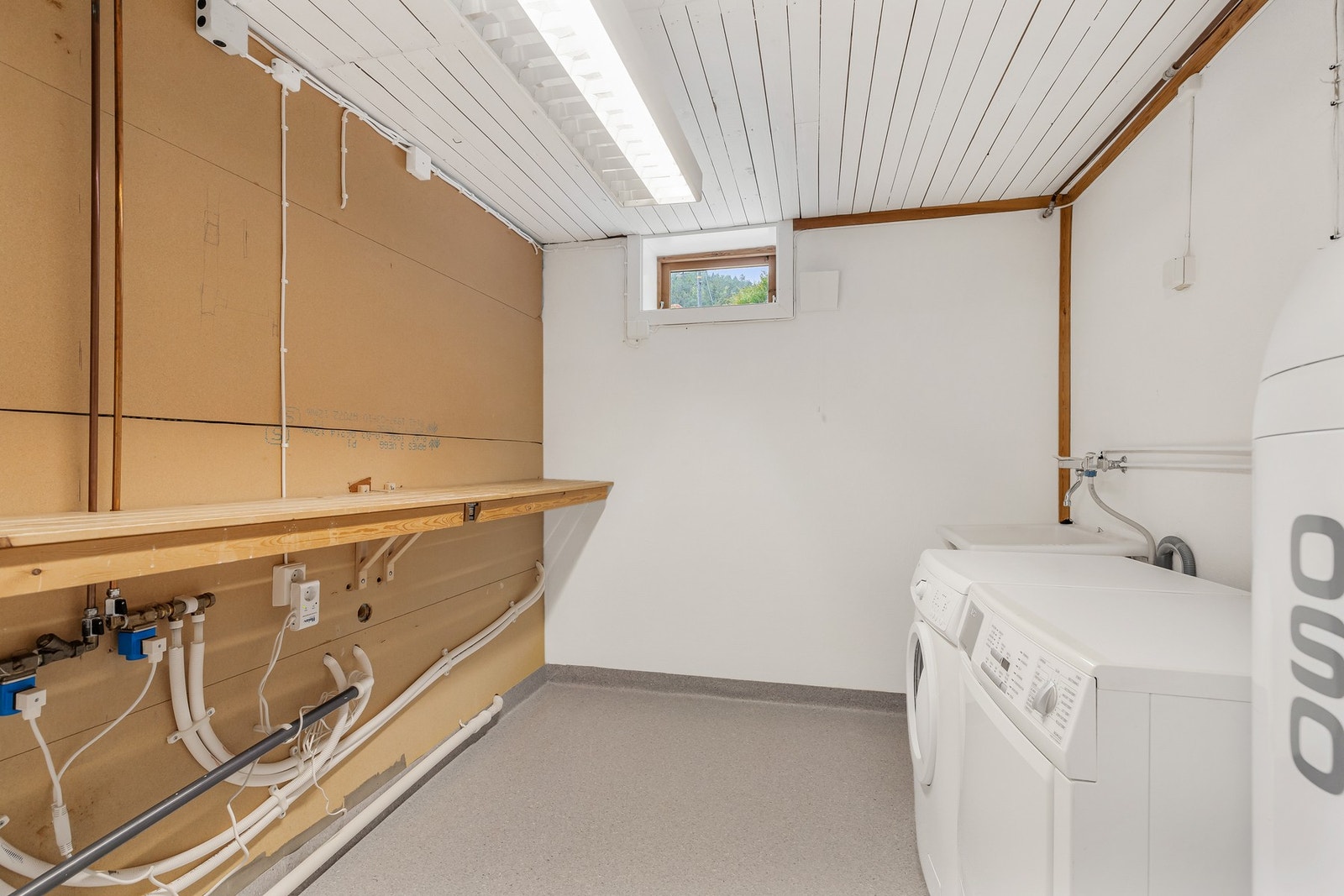 Vaskerom med gulvvarme, opplegg for vaskemaskin og vegghengt utslagsvask i plast med ettgreps blandebatteri Galleribilde