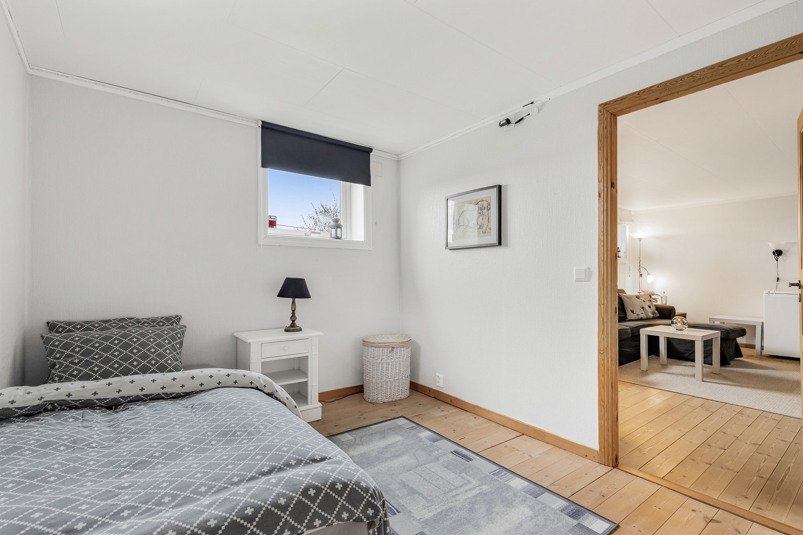 Soverom med heltrebord på gulv, tapet på vegger og takplater i himling Galleribilde