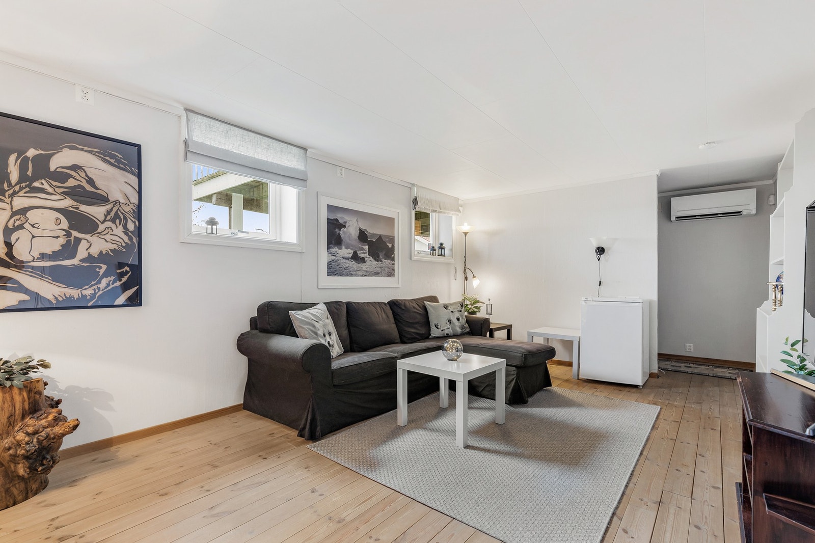 Kjellerstue med heltrebord på gulv, tapet på vegger og takplater i himling Galleribilde