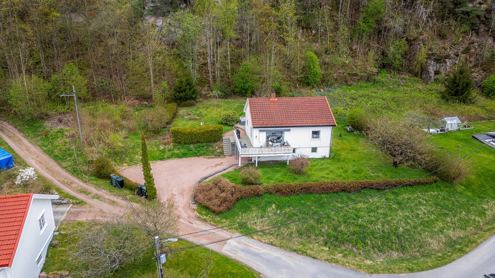 Tomten er pent opparbeidet med plenarealer, hekk, gruset gårdsplass og diverse beplantninger Galleribilde