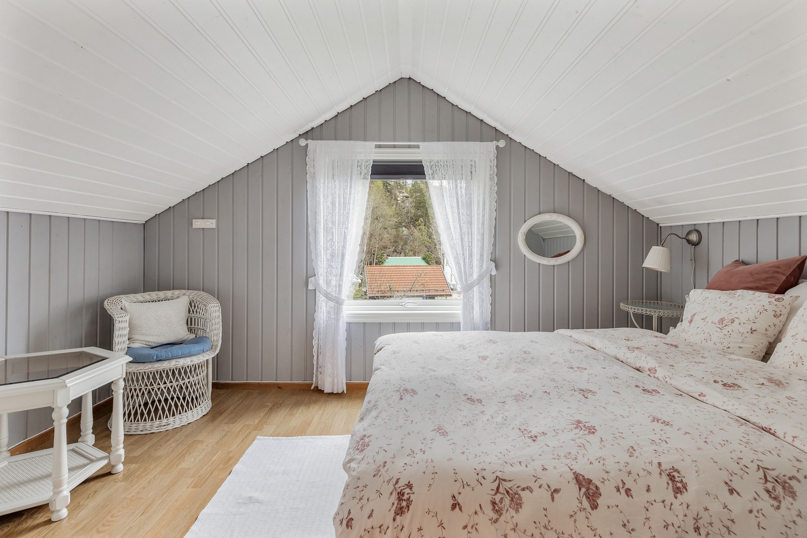 Lyst soverom med fin plass til dobbeltseng og annet møblement Galleribilde