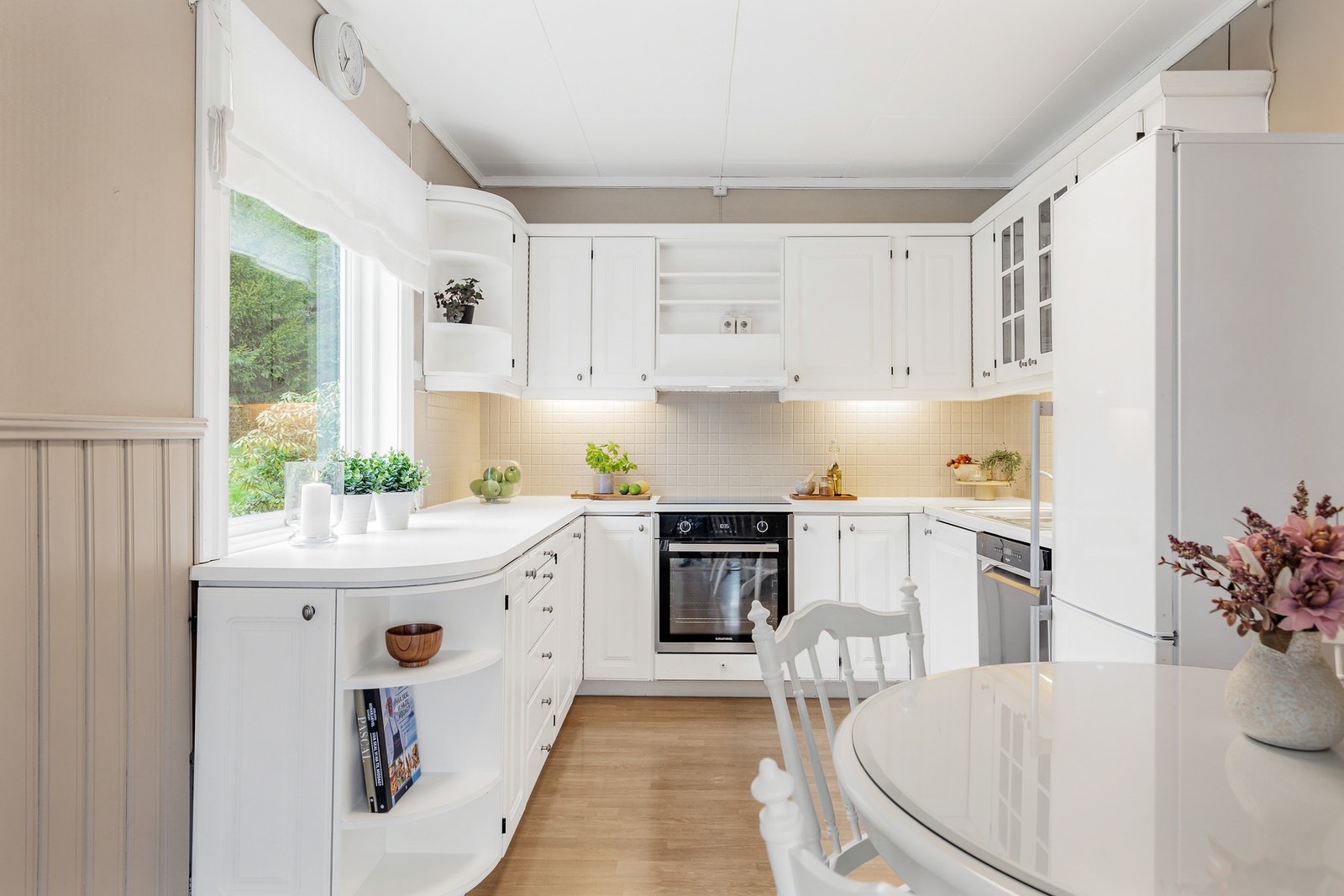 Kjøkkeninnredningen har profilerte fronter og laminert benkeplate med nedfelt platetopp og oppvaskkum i metall med ettgreps blandebatteri Galleribilde