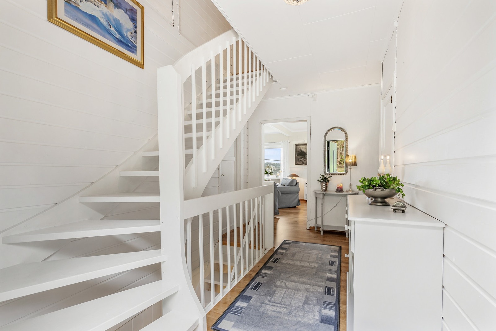 Det er fin plass til oppbevaring av yttertøy og sko i skyvedørsgarderobe med speilfronter litt lenger inn i gangen Galleribilde