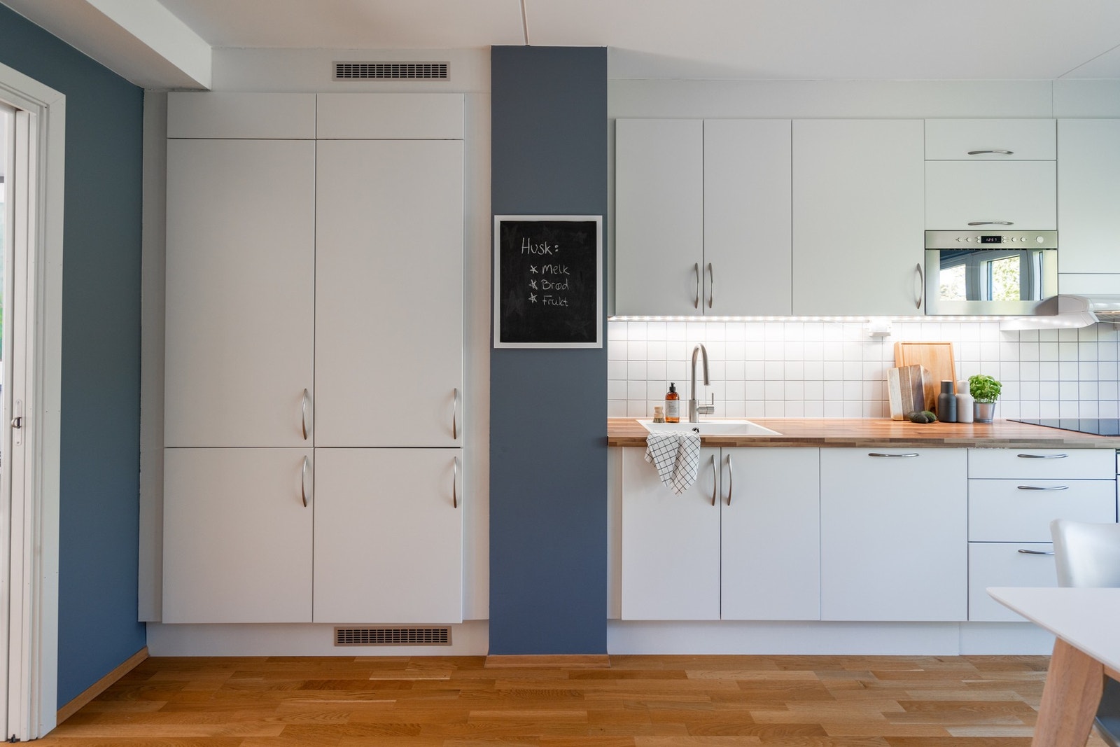 Aubo kjøkkeninnredning med integrert stekeovn, induksjonstopp, oppvaskmaskin, kjøl og frys. Galleribilde