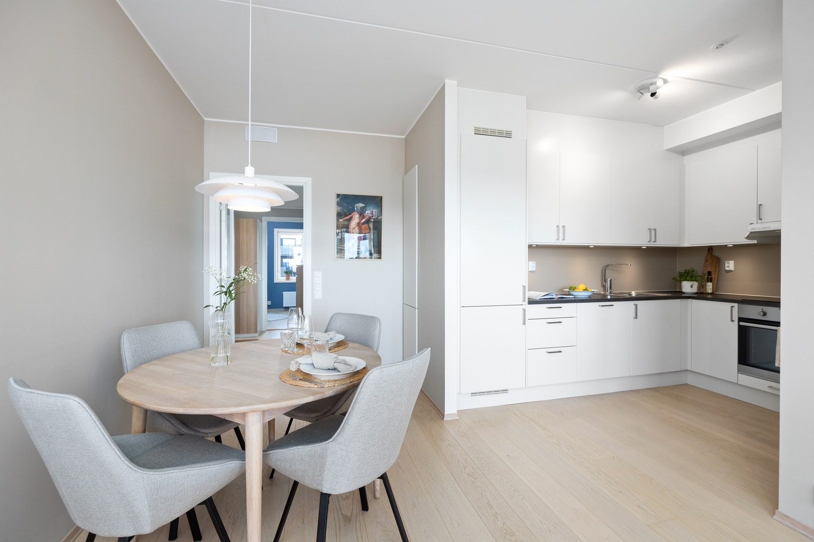 Stilren, moderne kjøkkeninnredning fra Norema med svært god skap- og benkeplass i åpen, men samtidig noe skjermet løsning med stuen Galleribilde