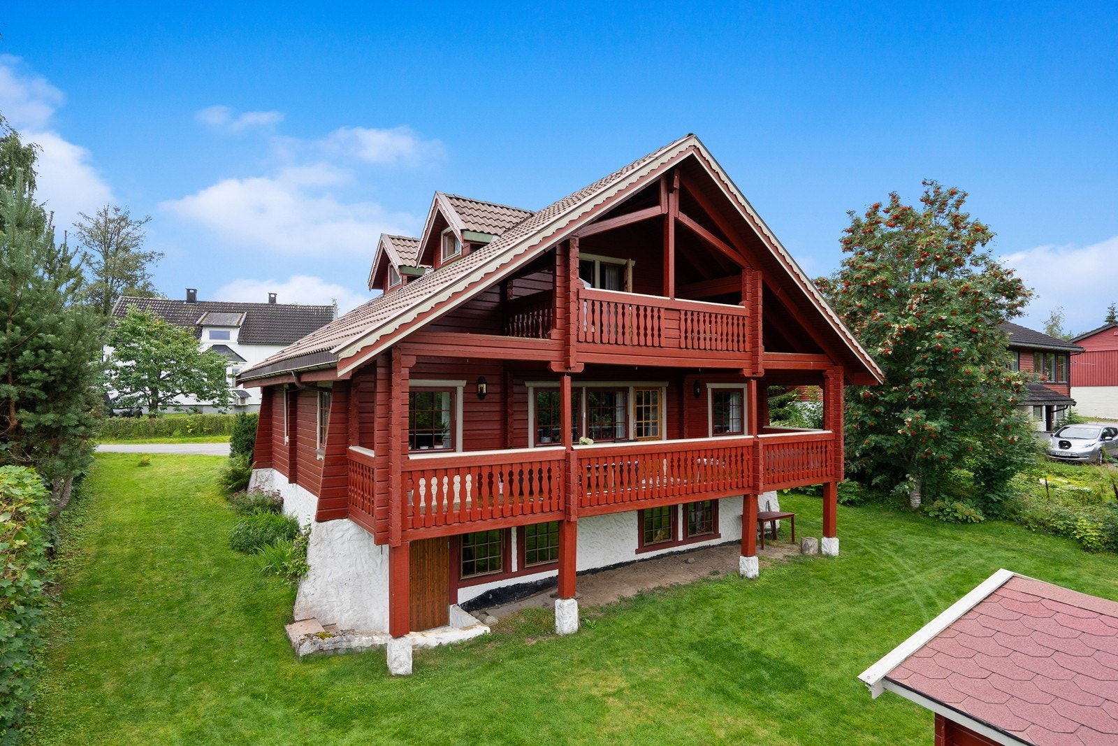 Fasade der man ser både balkong i loftsetasjen og verandaen i 1. etasje. Galleribilde