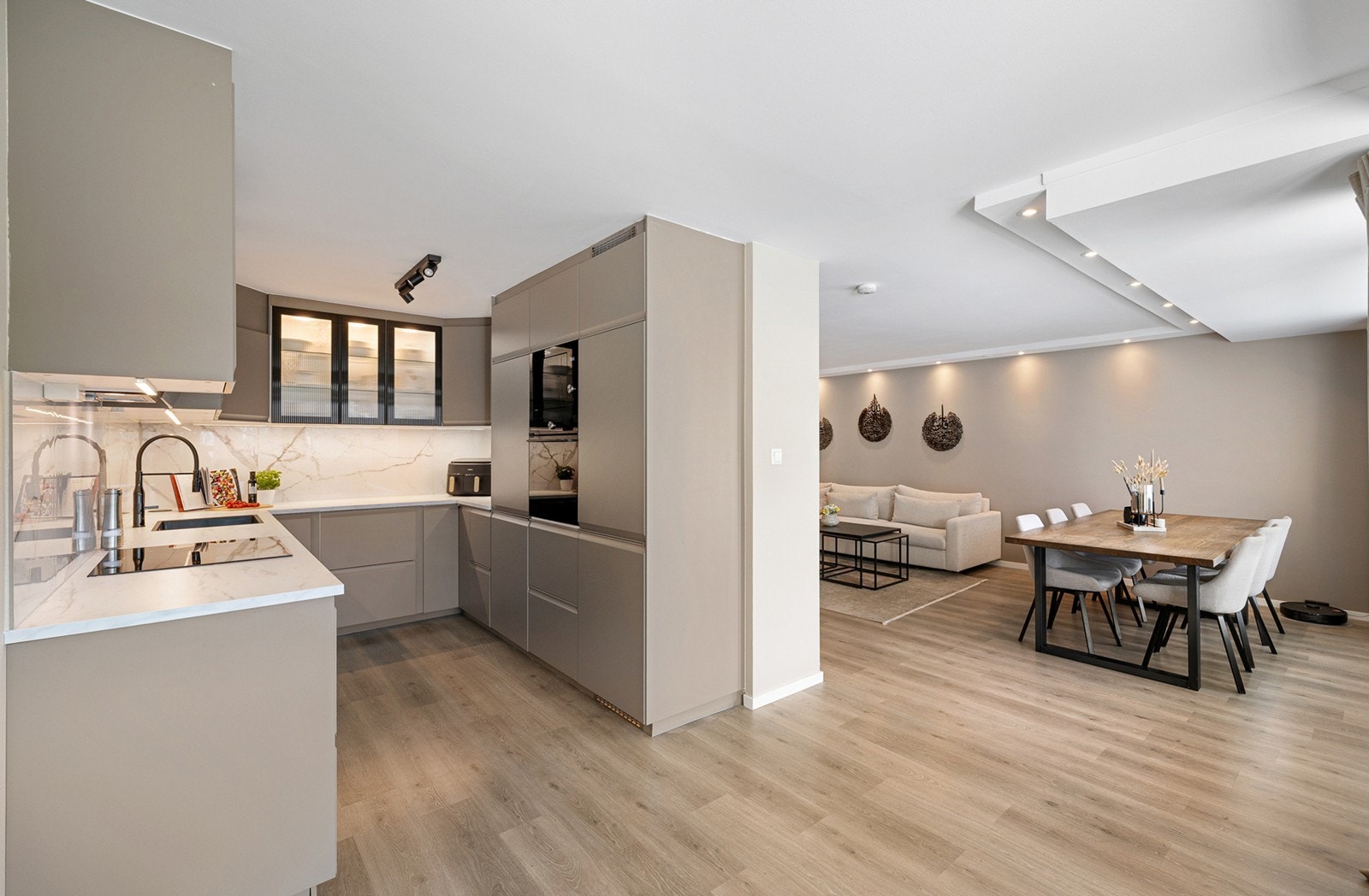 Et moderne og stilrent kjøkken fra 2023, med glatte fronter og laminert benkeplate med nedfelt oppvaskkum. Galleribilde