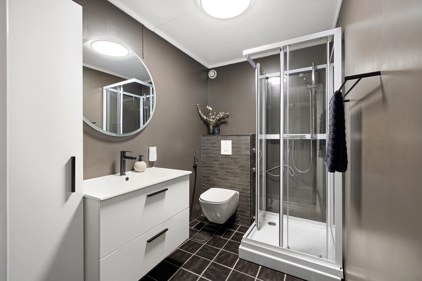 Lekkert bad med fliser på gulvet og behagelig gulvvarme. Badet ble pusset opp med nyere innredning i 2023. Galleribilde