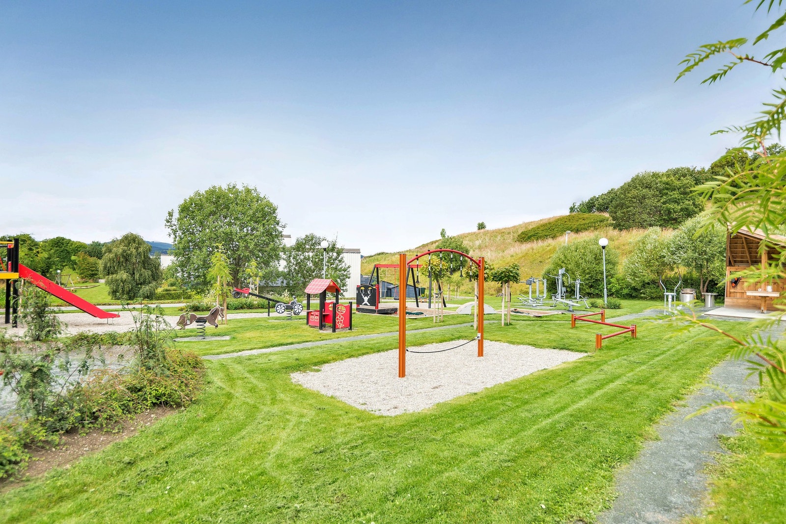 Et fantastisk nærområde, med store solrike grøntareal, som er opparbeidet med lekeplasser for de minste. Galleribilde